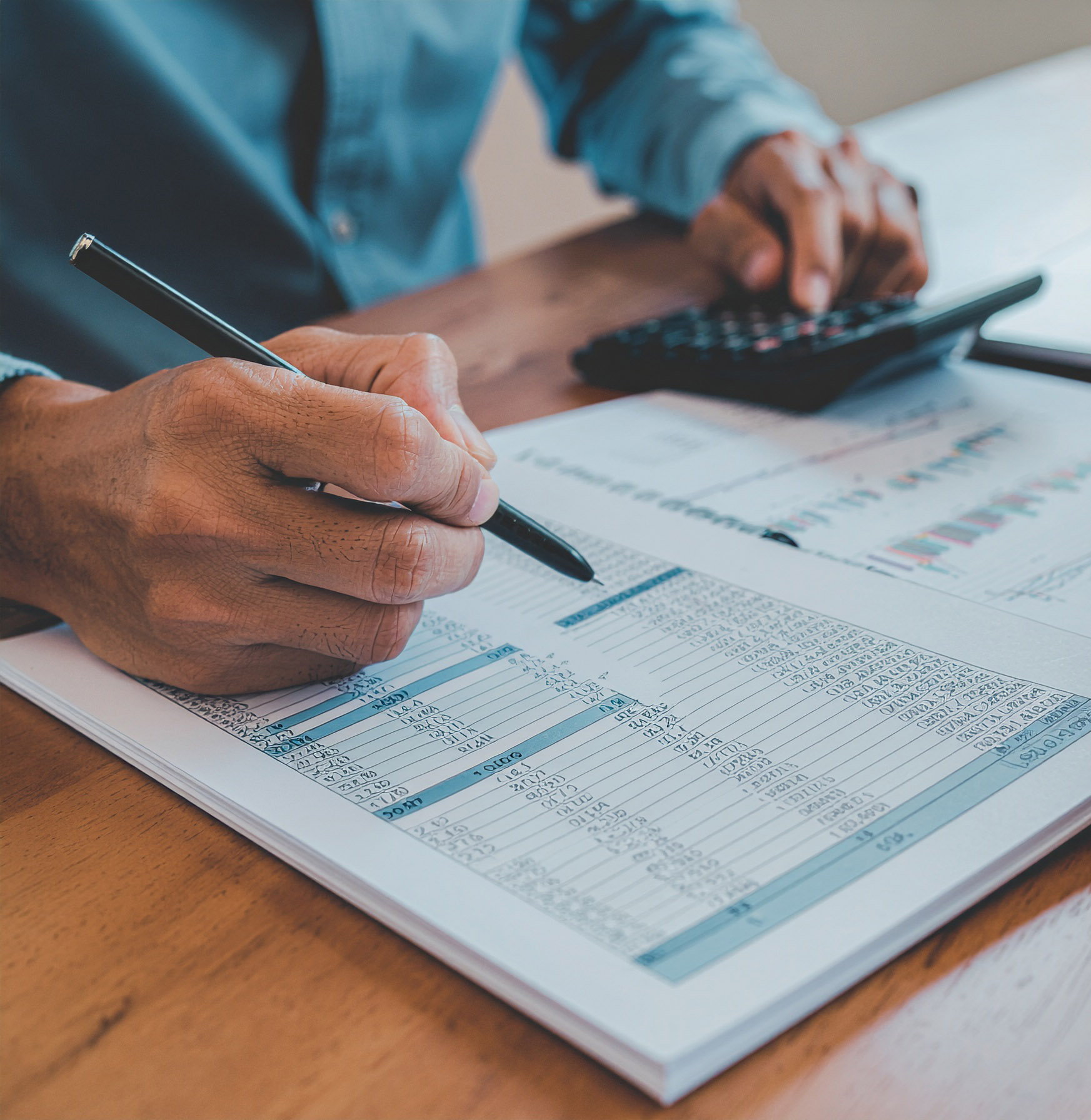 business accountant reviewing a spreadsheet and, working with a calculator